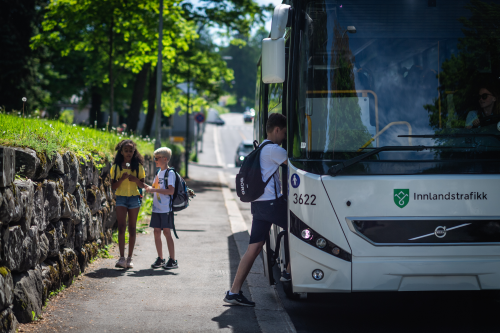 Bildet viser skolebarn som går om bord på en skolebuss.