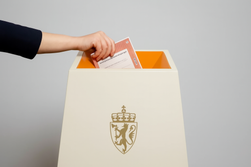 Arm som putter en stemme oppi valgurnen.