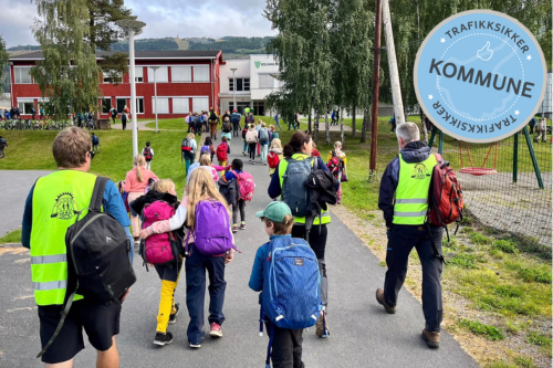 Skolebarn med refleksvester på vei til skole. Med stempel trafikksikker kommune.