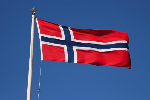 Norsk flagg som veiver i vinden på blå himmel